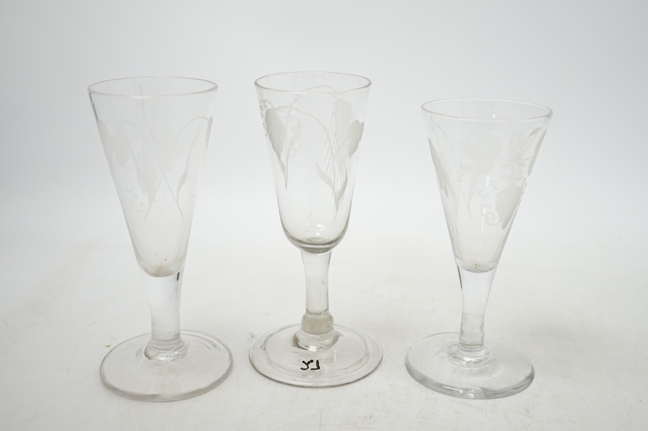 Three mid 18th century engraved ale glasses, all with hop decoration to the bowls, 14cm. Condition - good